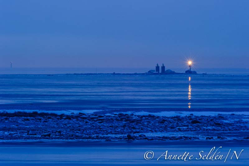 Kattegat / New Nidingen Lighthouse & Historical Twin Towers, left distant Fladen Lighthouse 
Permission granted.
Annette made this picture in the early morning hours, low humidity and a clear view.
To the right the new light flashing.
Beside it the historical Nidingen Dubbel Fyr. There where allready open fires at Nidingen from 1624.
To the left distant Fladen Lighthouse, also flashing, one can just see her helipad.
Keywords: Kattegat;Sweden;Offshore